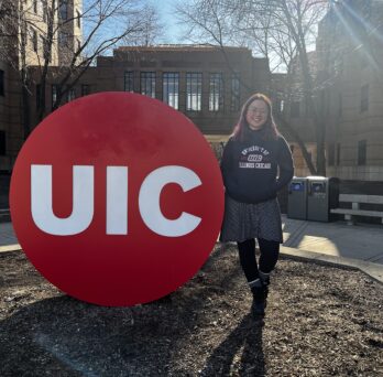 Photo of Mary next to UIC sign on campus
                  